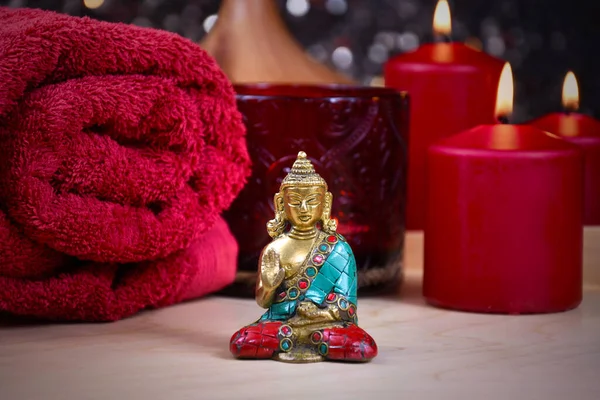 Zen spa still life with a buddha statue, red towel and candle stock photo images. Red spa and wellness setting with towels, candles and buddha statue. Beauty spa treatment composition images