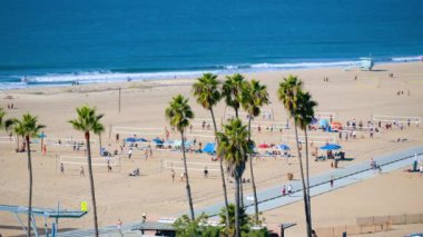 Basketbol ağları ve bisiklet yolu olan güneşli bir sahil manzarası. İnsanlar Santa Monica Sahili, Los Angeles, Kaliforniya 'da rahatlar. Yüksek kalite 4k görüntü