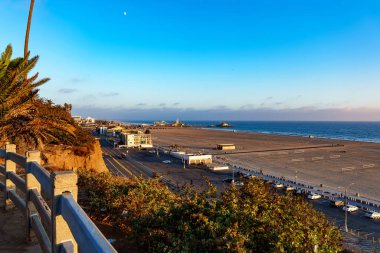 Santa Monica sahnesinin ön planında belirgin bir çitle güzel bir kumsal manzarası görebilirsiniz.