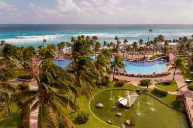 Şaşırtıcı derecede güzel bir manzara gösterişli palmiye ağaçları, sonsuz bir havuz, ve lüks bir tropikal tatil köyünde engin bir okyanus.