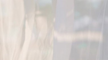 Saf perdelerden güzel bir şekilde çekilmiş sakin bir sahne, davetkar bir sahil manzarasını gözler önüne seriyor