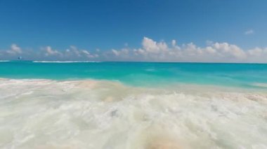 Tepemizde el değmemiş, berrak bir mavi gökyüzünün altında okyanus dalgalarını çarpıştırmanın nefes kesici güzelliğini tecrübe edin.