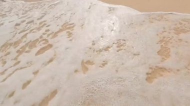 Güzel bir sahil şeridinin sakin ve sakin manzarası yumuşak dalgaların yumuşak ve altın kumla buluştuğu yer.