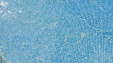Güzel, dingin bir manzara. Ilık güneş ışığını yansıtan canlı mavi bir mozaik havuz yüzeyi.