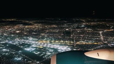 Los Angeles geceleri bir şehrin güzelliğini yukarıdan tecrübe eder. Bu video, ışıldayan ışıkları ve hareketli caddeleri olan canlı bir arazide süzülen bir uçağı gösteriyor.