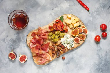 Jambonlu Antipasto tabağı, prosciutto, mavi peynir, kurutulmuş domates, incir ve zeytinli ahşap bord. Üst görünüm