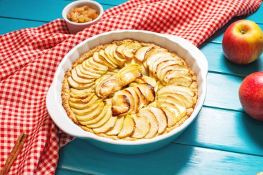 Homemade delicious fresh baked rustic apple pie on blue wooden background.