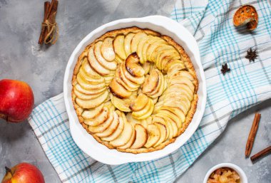 Homemade delicious fresh baked rustic apple pie on concrete background, top view.
