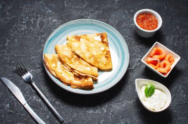 Rus ince krepleri ya da kırmızı havyarlı blini ve siyah masada somon balığı..