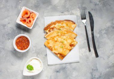 Rus ince krepleri ya da kırmızı havyarlı blini ve beton masada somon balığı. Üst görünüm.