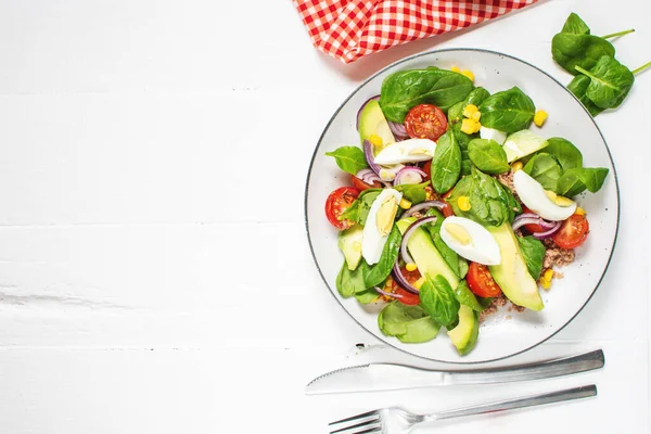 stock image Tuna salad - tuna, avocado, hard boiled eggs, cherry tomatoes, lettuce and onion on wooden table. Healthy food