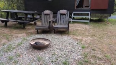 Bir sonbahar ormanının arka planında ahşap kaplamalı modüler çerçeve tipi tekerlekli bir daire. Yaşam ve turizm için mobil ekolojik alan
