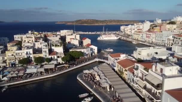 ギリシャのクレタ島の東部の港周辺のカラフルな建物を持つ美しい沿岸の町 アギオスニコスの空中ビュー — ストック動画