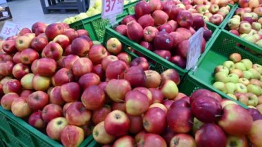 Canlı bir süpermarket sahnesinde elmalar raflarda. Bu süpermarket görüntülerinde raflardaki çeşitli elmaları inceleyin