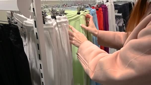 Γκρο Πλαν Ρούχα Κρεμάστρα Χρωματιστά Παντελόνια Στο Κατάστημα Ρούχων Γυναικεία — Αρχείο Βίντεο