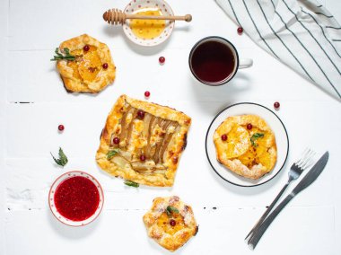 Beyaz ahşap arka planda portakallı ve armut dilimli tatlı turtalar.