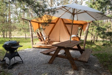 Ormanda piknik alanı ve barbekü ızgarası olan rahat bir çadır.