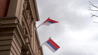 Sırbistan ve Gökyüzü 4K 'nın ulusal bayrağını sallıyor. Belgrad, Sırbistan - 2 Nisan 2023.