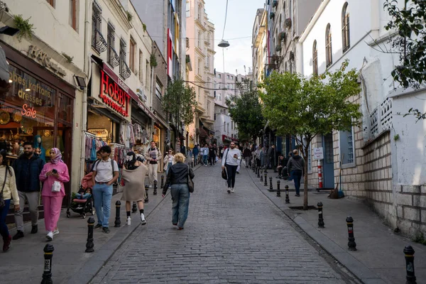 Galata bölgesindeki Galip Dede Caddesi 'ndeki insanlar ve dükkanlar. İstanbul, Türkiye - 3 Mayıs 2023.