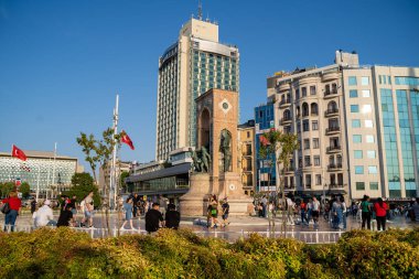 İstanbul Taksim Meydanı 'ndaki ünlü Cumhuriyet Anıtı önündeki turistler. İstanbul, Türkiye - 20 Haziran 2023.