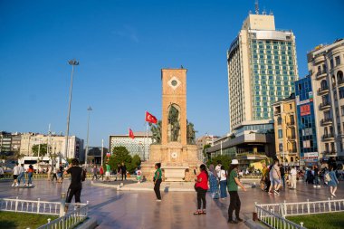 İstanbul Taksim Meydanı 'ndaki ünlü Cumhuriyet Anıtı önündeki turistler. İstanbul, Türkiye - 20 Haziran 2023.