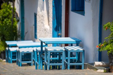 Beyaz mavi masalar ve caddedeki kafe tabureleri..