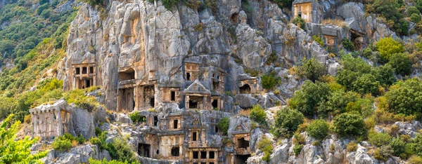 Myra Ancient City 'deki kaya kesimli mezarların panoramik görüntüsü. Myra, önce Lycian, sonra Antik Yunan, sonra Greko-Romen, sonra Bizans Yunancası, sonra da Lycia 'daki Osmanlı kasabası.