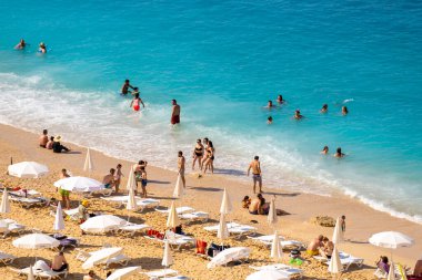 Turistler Kaputa 'da güneşleniyor ve yüzüyorlar. Kaputas Plajı, Kas ve Kalkan arasında küçük bir plajdır. Antalya, Türkiye - 10 Temmuz 2023.