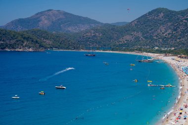 Oludeniz 'in Belcekiz (Belcegiz) plajında güneşlenen ve yüzen turistler (Mavi Göl). Mugla, Türkiye - 10 Temmuz 2023.