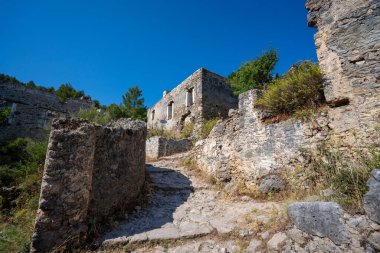Hayalet şehir Kayakoy 'daki Stone Caddesi. Kayakoy, Fethiye ilçesine bağlı bir Yunan köyü. Mugla, Türkiye - 10 Temmuz 2023.