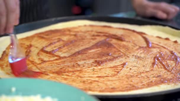 ピザ生地にトマトソースを追加 4Kシェフベイカー キッチンでピザを作る — ストック動画