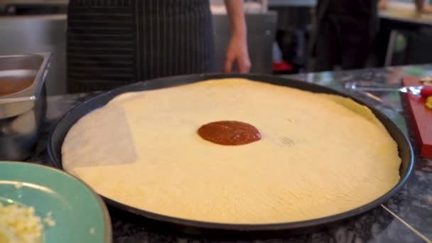 在披萨面团上加番茄酱4K厨师在厨房做披萨 — 图库视频影像