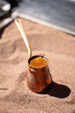 Sıcak kum üzerine hazırlanan cezve içinde geleneksel Türk kahvesi.