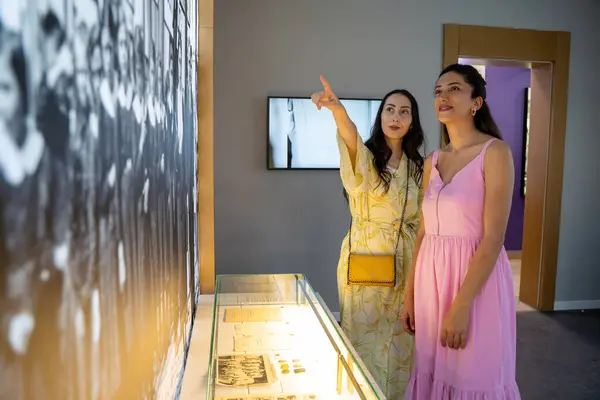 Sanat galerisindeki resimlere bakan genç bayan ziyaretçiler. Ankara, Türkiye - 24 Eylül 2023.
