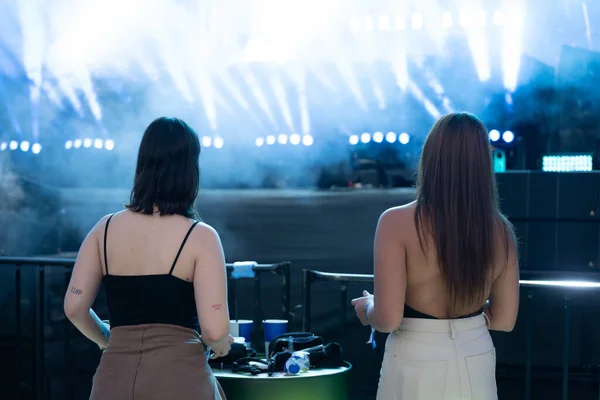 Two young women with their backs turned at the party.