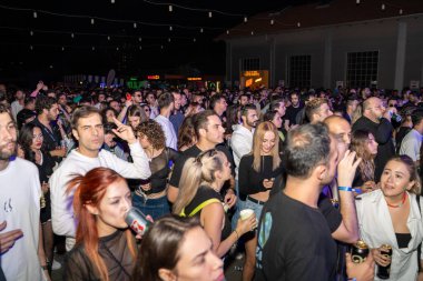 Bir grup neşeli genç insan tekno parti sırasında eğleniyor. Gece partisindeki performans gösterisi. Ankara, Türkiye - 24 Eylül 2023.