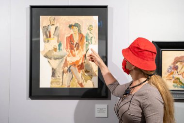 Sanat galerisinde resim yapan kırmızı şapkalı bir kadın. Ankara, Türkiye - 1 Ekim 2023.