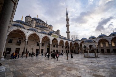 Mavi Cami 'nin (Sultan Ahmed Camii) avlusundaki turistler. İstanbul, Türkiye - 23 Aralık 2023.