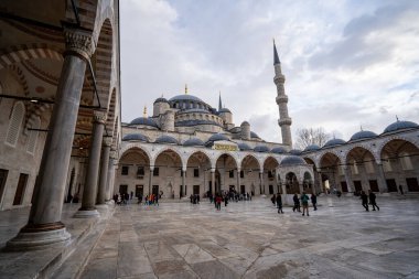 Mavi Cami 'nin (Sultan Ahmed Camii) avlusundaki turistler. İstanbul, Türkiye - 23 Aralık 2023.