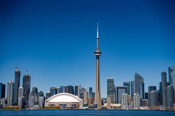 Вид на CN Tower и Rogers Center в центре Торонто с центрального острова Торонто. Торонто, Канада - 30 апреля 2024 года.