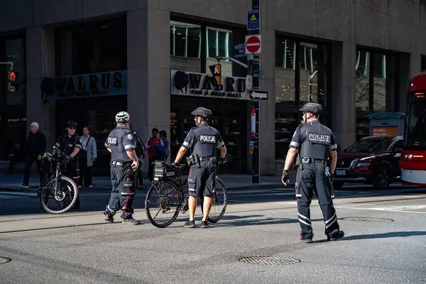 Bisikletli polis memurları sokaklarda devriye geziyor. Toronto, Kanada - 30 Nisan 2024.