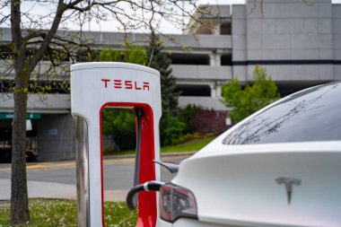 İstasyonda modern Tesla elektrikli arabaları (yeni enerji araçları, NEV) şarj ediliyor. Toronto, Kanada - 14 Mayıs 2024.