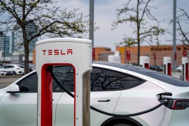 İstasyonda modern Tesla elektrikli arabaları (yeni enerji araçları, NEV) şarj ediliyor. Toronto, Kanada - 14 Mayıs 2024.