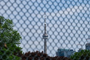 Çitlerin arkasındaki CN Kulesi 'nin görüntüsü. Toronto, Kanada - 25 Mayıs 2024.