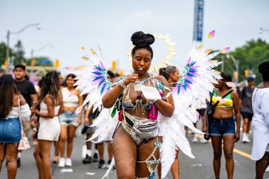 Renkli kostümler giymiş maskeli ve dansçılar Toronto Karayipler Karnavalı 'na katılıyor. Toronto, Kanada - 3 Ağustos 2024.