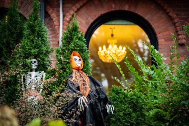 Evin ön kapısında iskeletli cadılar bayramı süslemeleri.