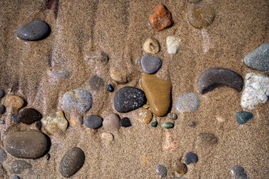 Kumsalda kumların ve taşların dokusu.