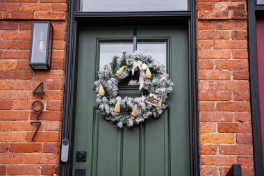 Evin kapısında Noel çelengi ve Noel süsleri var..