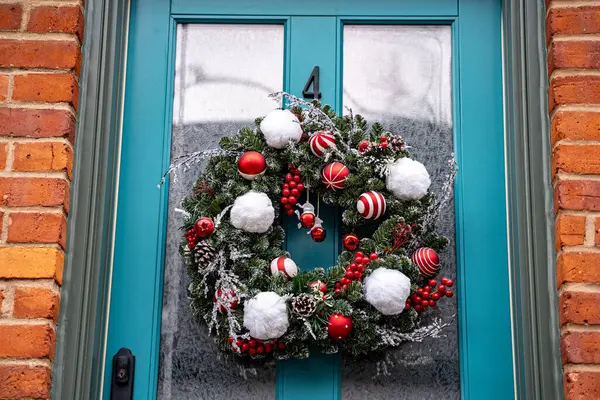 Evin kapısında Noel çelengi ve Noel süsleri var..