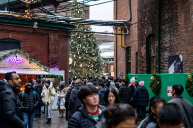 People visiting the Christmas Village in the Distillery District. View of the Toronto Christmas Market. Toronto, Canada - December 24, 2024. clipart